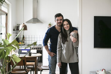 Portrait of smiling couple standing by wall at home - MASF07280