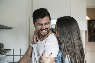 Lächelndes Paar, das sich in der Küche stehend ansieht - MASF07289