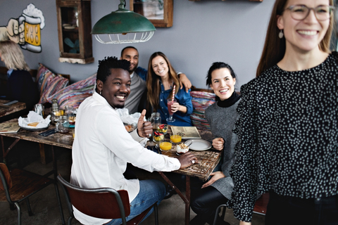 Cheerful multi-ethnic friends enjoying brunch at restaurant stock photo