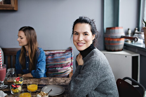 Porträt einer lächelnden Frau beim Brunch mit einem Freund am Tisch - MASF07547