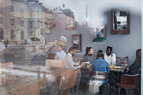 Menschen genießen Brunch im Restaurant durch Glasfenster gesehen - MASF07558