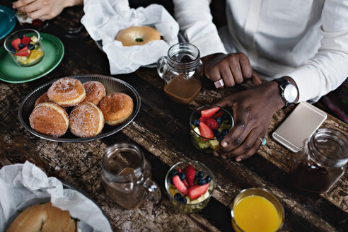 Mittelteil eines jungen Mannes beim Brunch am Esstisch - MASF07564