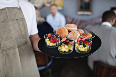 Mittelteil eines Eigentümers, der ein Essen in einem Serviertablett im Restaurant hält - MASF07571