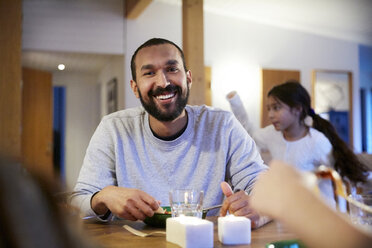 Lächelnder Mann beim Essen mit der Familie zu Hause - MASF07595