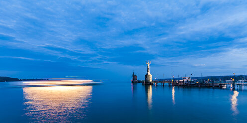 Germany, Constance, view to port entrance with lighthouse and Imperia at twilight - WDF04644
