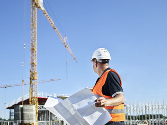 Construction worker with blueprint on construction site - CVF00334