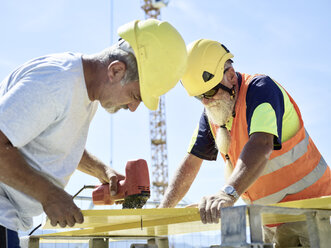 Bauarbeiter beim Schneiden von Sperrholz mit einer Stichsäge auf einer Baustelle - CVF00335