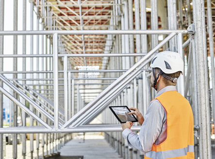 Architekt mit Tablet und Schutzhelm auf einer Baustelle - CVF00339