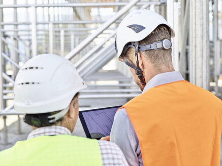 Architekt und Polier mit Tablet und Schutzhelm auf einer Baustelle - CVF00340