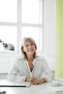 Porträt einer lächelnden reifen Geschäftsfrau am Schreibtisch - HHLMF00245