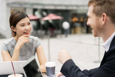 Young businesswoman and man having discussion at sidewalk cafe - ISF00003