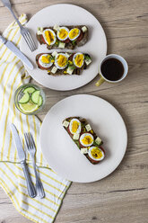 Vegetarisches Frühstück mit Brot, Eiern, Tomatenscheiben auf Teller und Kaffee - GIOF03931