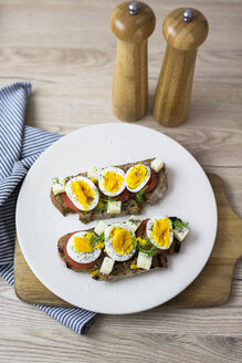 Vegetarisches Frühstück mit Brot, Eiern und Tomatenscheiben auf einem Teller - GIOF03933