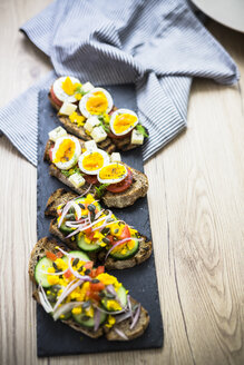 Vegetarisches Frühstück mit Brot, Eiern, Tomatenscheiben und Gurkenscheiben auf Schiefer - GIOF03937