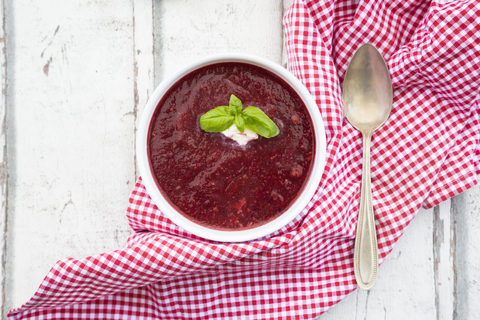 Beetroot soup in bowl on white wood stock photo