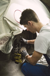 Mechaniker repariert den Bremssattel eines Autos in einer Werkstatt - RAEF02003