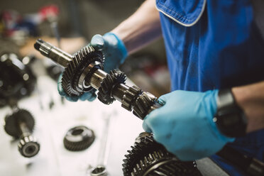 Nahaufnahme eines Mechanikers bei der Arbeit an einem Auto in einer Werkstatt - RAEF02016