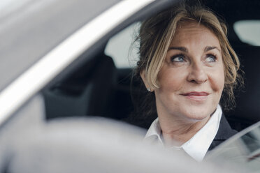 Portrait of smiling senior businesswoman in car - KNSF03815