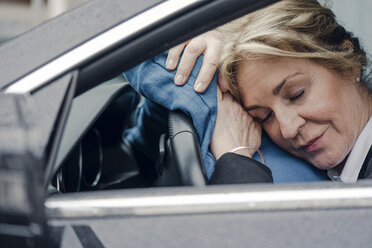 Ältere Geschäftsfrau schläft im Auto - KNSF03816