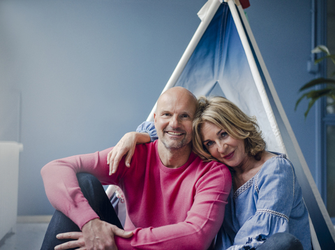Porträt eines lächelnden Paares am Tipi im Haus, lizenzfreies Stockfoto