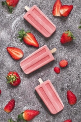 Three homemade strawberry ice lollies and strawberries on marble - RTBF01250