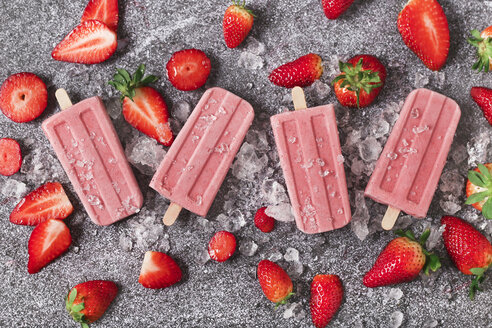 Four homemade strawberry ice lollies, ice and strawberries on marble - RTBF01251