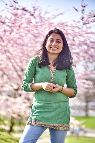 Portrait of happy young woman in a park at cherry blossom tree stock photo