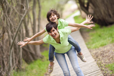 Happy mother and daughter having fun on boardwalk - JSMF00193