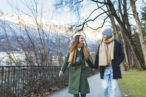 Österreich, Innsbruck, glückliches junges Paar, das im Winter Hand in Hand spazieren geht - WPEF00227