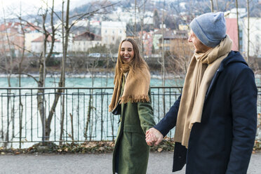 Österreich, Innsbruck, glückliches junges Paar, das im Winter Hand in Hand spazieren geht - WPEF00230