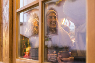 Junges Paar trinkt Glühwein auf dem Weihnachtsmarkt - WPEF00239