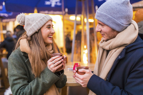 Happy young couple drinking mulled wine at Christmas market stock photo