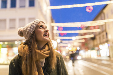 Zufriedene junge Frau auf der Straße zur Weihnachtszeit - WPEF00248