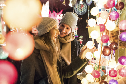 Young couple watching offerings at Christmas market stock photo