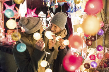 Young couple watching offerings at Christmas market - WPEF00250