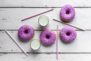 Four pink doughnuts, two glasses of milk and straws on white wood - SARF03704