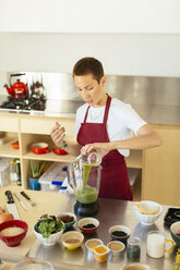 Frau bereitet einen Smoothie in der Küche zu - EBSF02418