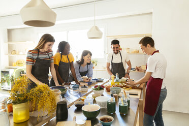 Freunde und Ausbilder in einem Kochworkshop bei der Zubereitung von Speisen - EBSF02434