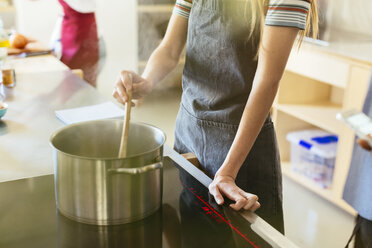 Frau rührt in Kochtopf in Küche - EBSF02441