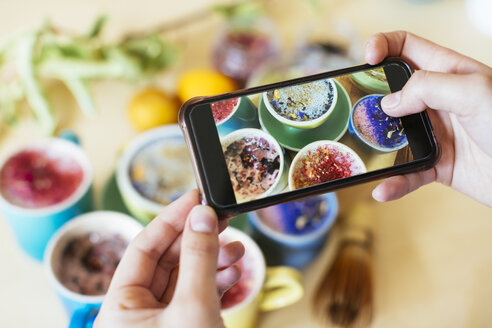 Woman taking smartphone picture of various colorful drinks - EBSF02473