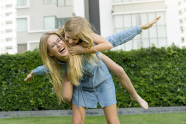 Happy mother and daughter having fun in urban city garden - SBOF01468