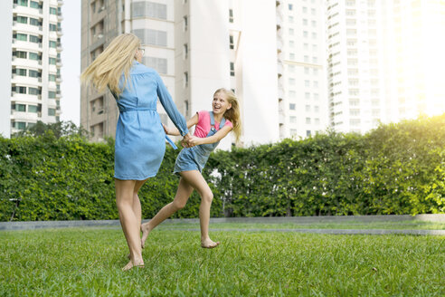 Glückliche Mutter und Tochter haben Spaß im städtischen Garten - SBOF01470