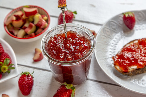 Glass of strawberry rhubarb marmelade on breakfast table - SARF03706