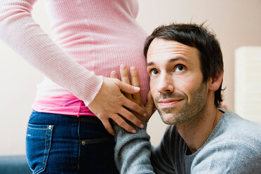 Mann hört auf den schwangeren Bauch seiner Frau - CUF00788