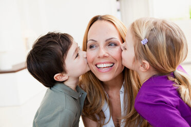 Brother and sister kissing her mother - CUF00799