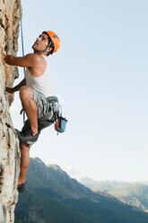 Climber scaling steep rock face - CUF00890