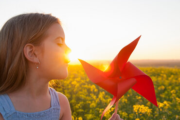 Girl playing with pinwheel outdoors - CUF00924