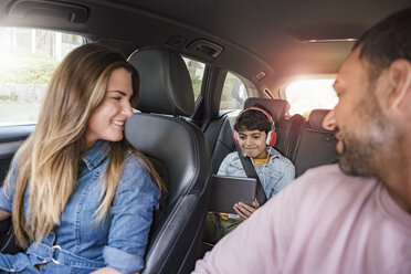 Familie auf einer Autoreise mit einem Jungen, der ein Tablet benutzt - DIGF04137