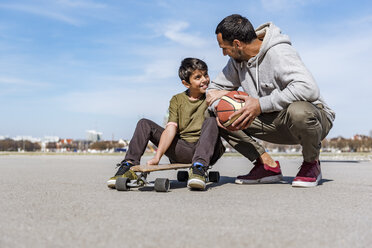 Father and son with longboard and basketball outdoors - DIGF04157