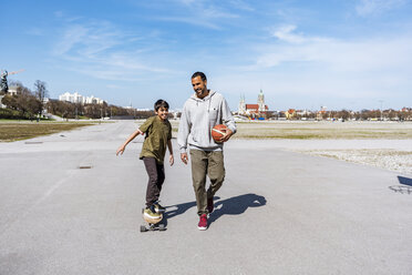 Father and son with longboard and basketball outdoors - DIGF04159